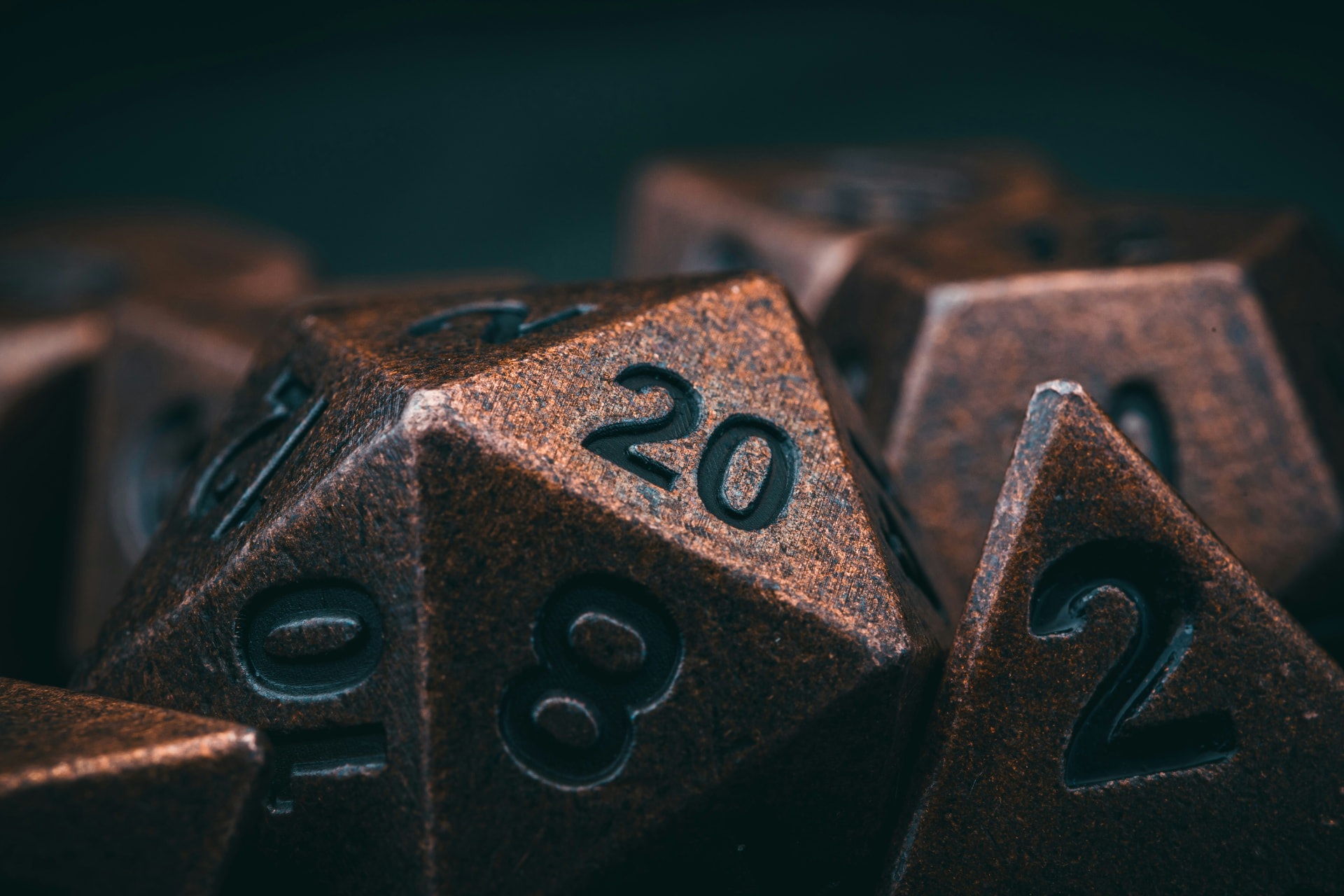 Close-up of bronze metal polyhedral dice with the 20 face showing
